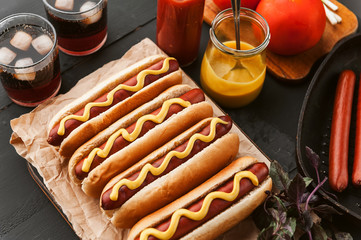 American hot dog with ingredients on a dark wooden background