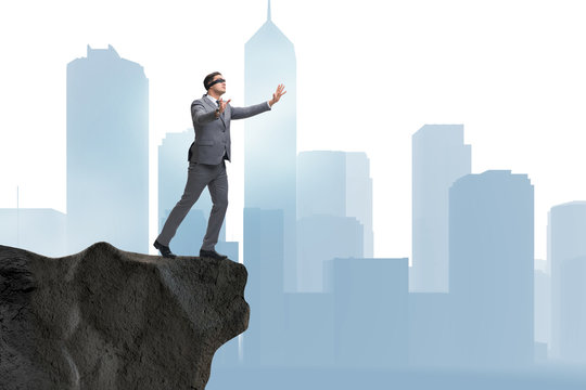 Blindfold Businessman Standing On Tip Of Cliff