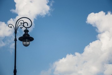 an antique street lamp against blue sky