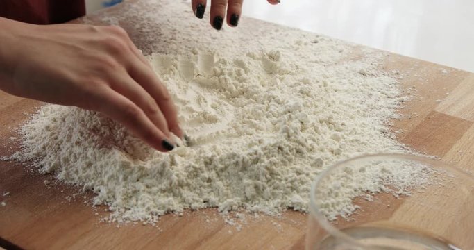 woman makes a dough on a wooden tablet. closeup