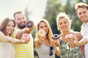 Group of friends eating donuts outdoors