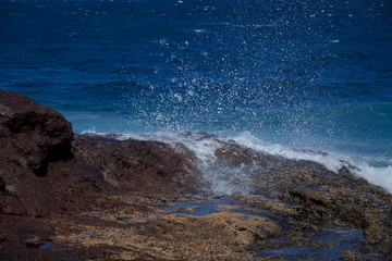 Stony ocean shore. Coast of the ocean on the islands. Canary Islands. Spray of the ocean
