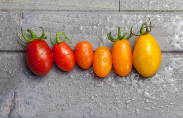 Cherry tomatoes in a row for color nuance on wooden background
