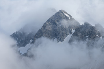 Fototapeta na wymiar high mount peak in a dense clouds