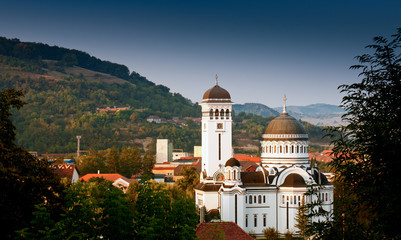 Fototapeta na wymiar A white Orthodox church surrounded by countryside in Transylvania, Sighisoara, Romania