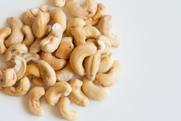 Heap of cashew nuts on white surface