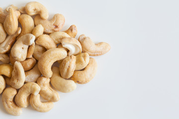 Heap of cashew nuts on white surface