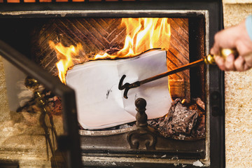 Sheets of paper burning in fire of fireplace.