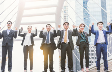 Fototapeta premium happy Successful business group People Hands Raised successful with city background Successful business group with arms up with city background