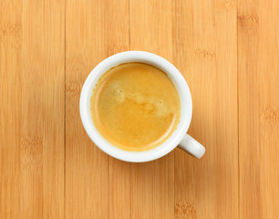 White cup of hot espresso coffee on wood table, background