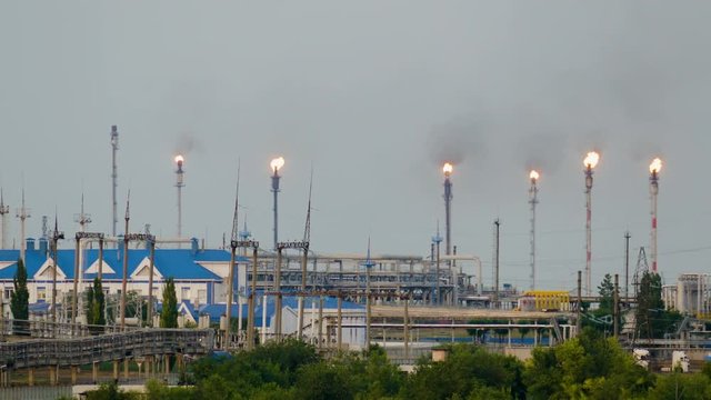 Huge gas and oil processing plant with burning torches, pipes and distillation of the complex