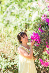 Fototapeta premium Outdoor portrait of young beautiful fashionable lady posing near flowering tree. Girl looking aside.