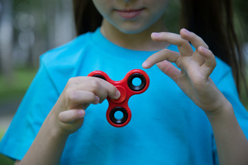 Little girl is playing spinner in hand