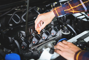 Fototapeta premium Close up hands checking lube oil level of car engine from deep-stick for service and maintenance concept