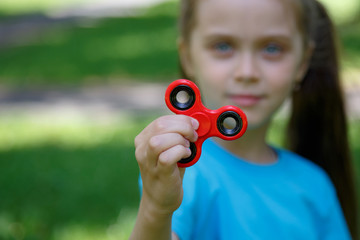 Young girl play with fidget spinner stress relieving toy