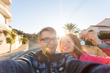 real estate: happy couple showing keys of their new house