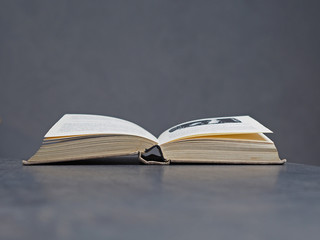 open old book with beige canvas binding, soft grey background