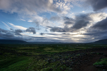 Naklejka na ściany i meble Iceland - Volcanic stones and green hills at dawn
