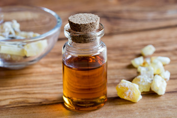 A bottle of frankincense essential oil with frankincense crystals