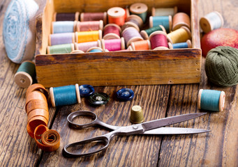Fototapeta na wymiar sewing tools : scissors, bobbins with thread and needles
