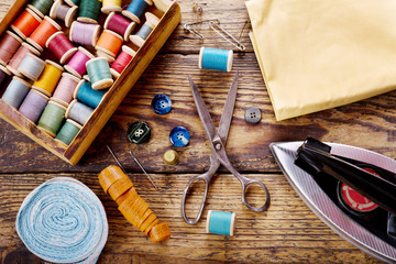 Fototapeta na wymiar sewing tools : scissors, bobbins with thread and iron