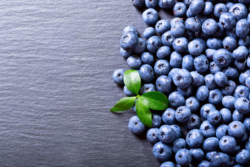 fresh blueberries with leaf on dark table