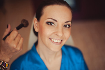 Beautiful bride in the morning doing makeup