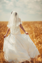 Beautiful elegant bride in a wheat field