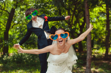 Cheerful wedding couple in glasses in the form of heart