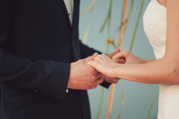Bride and groom hold hands at the ceremony