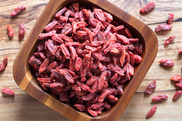 Dried goji berries in a wooden bowl