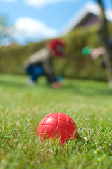 petanque red ball with child in background
