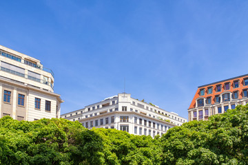 Beautiful building facades at Gendarmen Markt in Berlin beneath the blue sky.