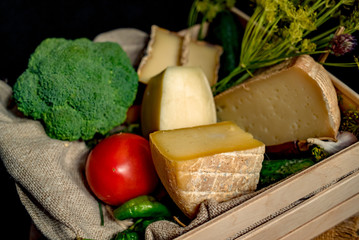 Kraft homemade cheese with vegetables  in a wood box on the dark background 