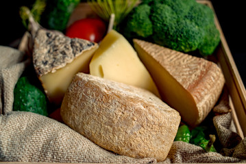 Kraft homemade cheese with vegetables  in a wood box on the dark background 