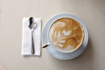 A cup of coffee and a spoon on a vintage table