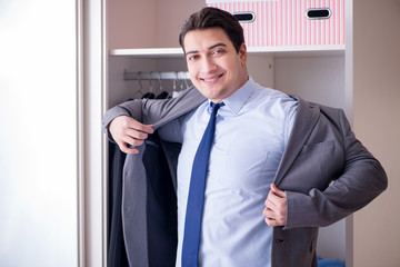 Fototapeta premium Young man businessman getting dressed for work
