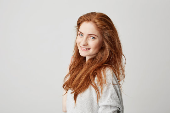 Portrait of cheerful happy beautiful girl with foxy hair smiling looking at camera over white background.