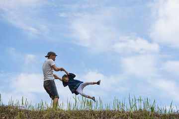 Father and daughter playing in the meadow