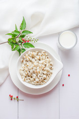 Healthy breakfast with boiled job's tears porridge in white bowl on wooden table.
