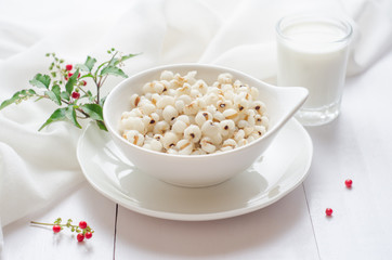 Healthy breakfast with boiled job's tears porridge in white bowl on wooden table.