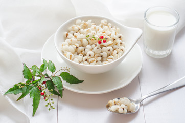 Healthy breakfast with boiled job's tears porridge in white bowl on wooden table.