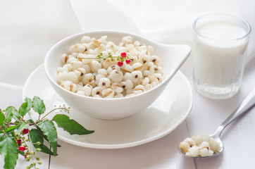 Healthy breakfast with boiled job's tears porridge in white bowl on wooden table.