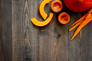 Baby food. Pumpkin puree on dark wooden table background top view copyspace