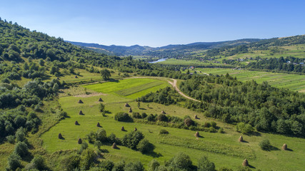 Fototapeta na wymiar a beautiful summer landscape shot from a bird's eye view. mountains, river, green fields and villages.