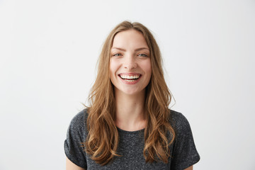 Young cheerful happy girl smiling laughing looking at camera over white background.