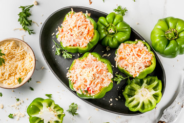 Autumn recipes. Home stuffed bell pepper with minced meat, carrots, tomatoes, herbs, cheese. Cooking process. White marble table. Stuffed pepper ready for baking, in pan, Copy space top view