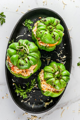 Autumn recipes. Homemade stuffed bell pepper with minced meat, carrots, tomatoes, herbs, cheese. On white marble table, in baking pan, Copy space top view