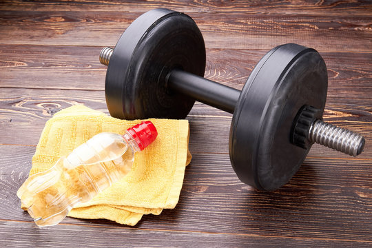 Dumbbell, towel, bottle close up. Concept of gym and sport activity.