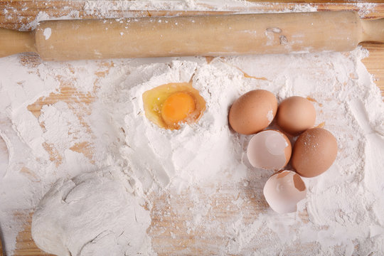 A dough with eggs and utensils.